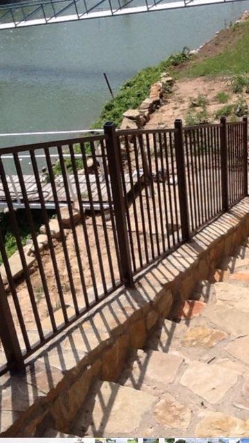 Ornamental iron fence along a riverside stone step path in Wise County