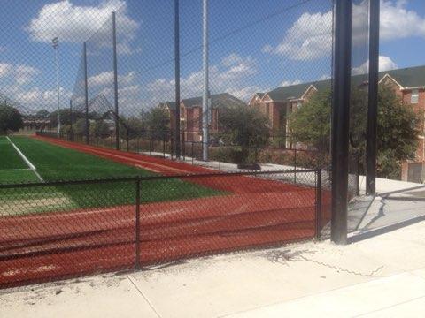 Chain link fence enclosing a commercial sports field and track