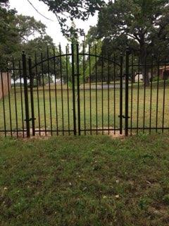Black arched double ornamental iron entry gate in Decatur, TX