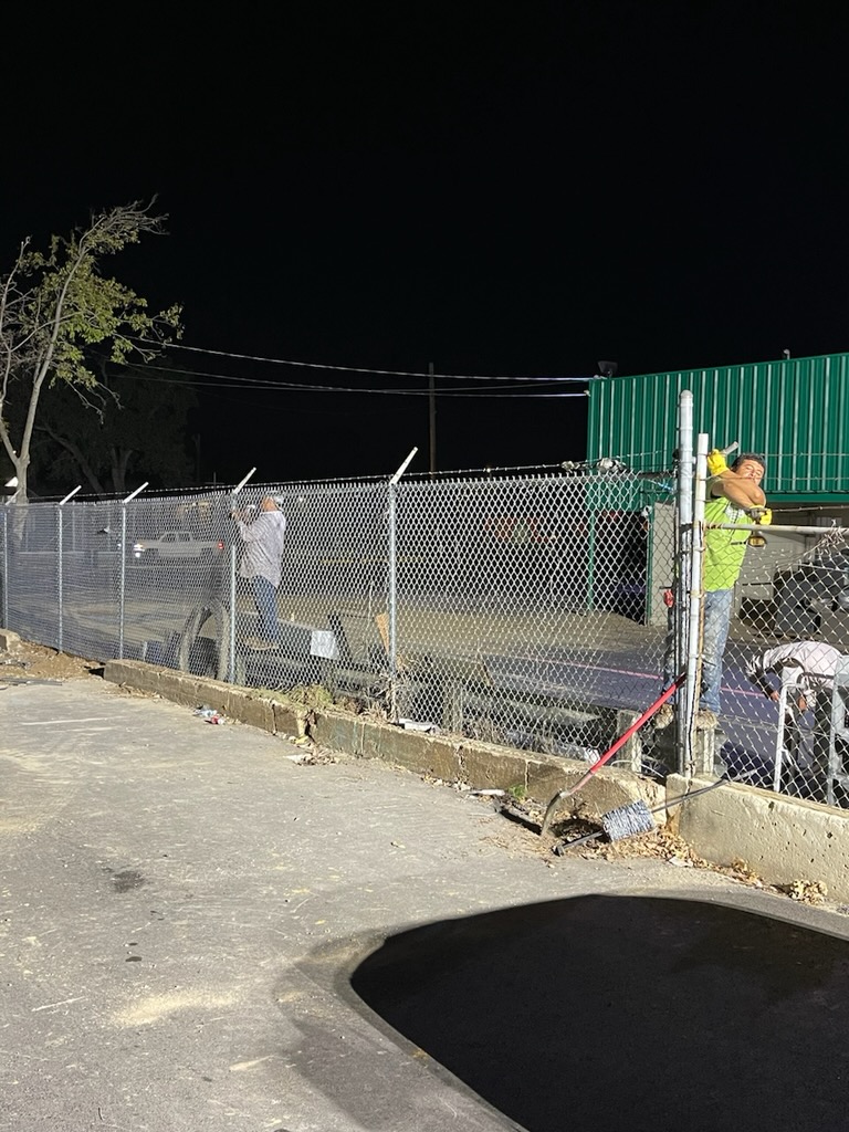 Affordable Fencing crew installing commercial chain link fence at night