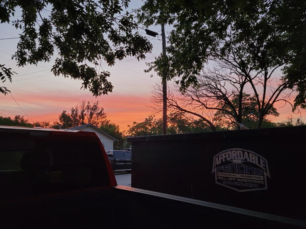 Affordable Fencing truck parked on a job site in Decatur, TX at sunset