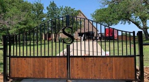 Custom driveway gate with a monogram medallion built for a Decatur, TX ranch